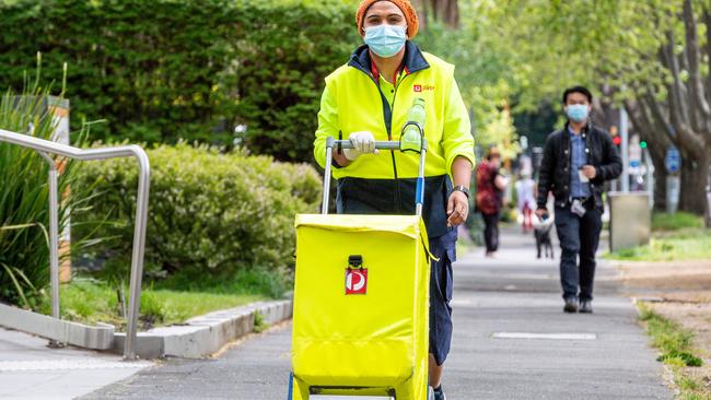 Postie Savitha Shanabinagondikoppalu, who was employed in a recruiting drive last year, delivers mail along St Kilda Road. Picture: Jake Nowakowski