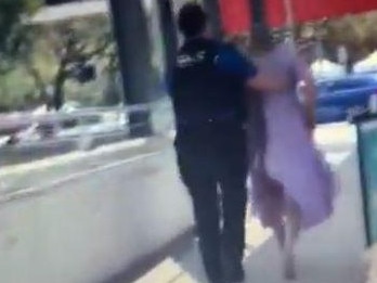 This still from a video shows a man in a purple hospital gown being moved out of the Royal Brisbane and Women's Hospital by security. Picture: Supplied