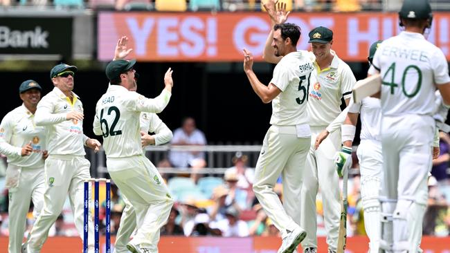 Mitchell Starc and the Aussie celebrate the wicket of Dean Elgar early on day one of the first Test. Picture: Bradley Kanaris/Getty Images