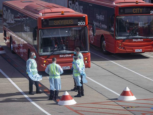 Staff at Melbourne Airport prepare to transfer returning travellers to hotel quarantine. Picture: NCA NewsWire/Ian Currie