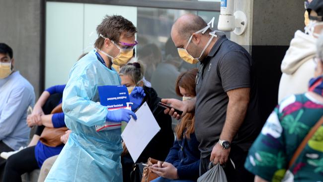 People queue outside the Royal Melbourne Hospital on Tuesday waiting to be tested for the coronavirus. Picture: Andrew Henshaw