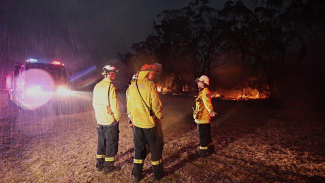 RFS firefighters from Glenbrook-Lapstone in the Blue Mountains enjoy the surprise rain in Yanderra with the change on Saturday night. Picture: Adam Yip