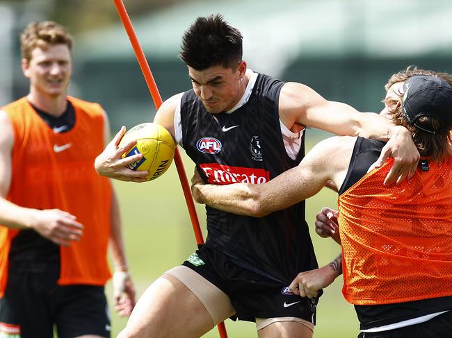 MELBOURNE, AUSTRALIA - DECEMBER 06: Brayden Maynard of the Magpies handballs whilst being tackled by Nathan Murphy of the Magpies (R) and Trey Ruscoe of the Magpies during a Collingwood Magpies AFL training session at Holden Centre on December 06, 2021 in Melbourne, Australia. (Photo by Daniel Pockett/Getty Images)