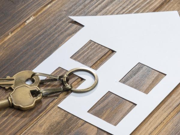 house and key with Calculator on wooden background