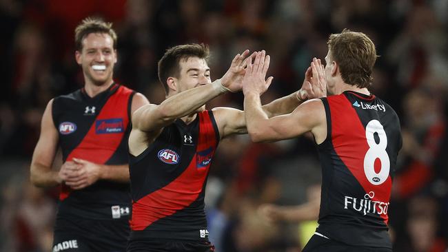 MELBOURNE, AUSTRALIA - JULY 09: Ben Hobbs of the Bombers (R) celebrates with Zach Merrett of the Bombers (C) and Darcy Parish of the Bombers after kicking a goal during the round 17 AFL match between Essendon Bombers and Adelaide Crows at Marvel Stadium, on July 09, 2023, in Melbourne, Australia. (Photo by Daniel Pockett/Getty Images)