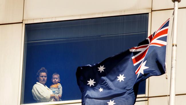 A woman and her child look out a window from quarantine at the Park Royal Hotel at Melbourne Airport. Picture: David Geraghty