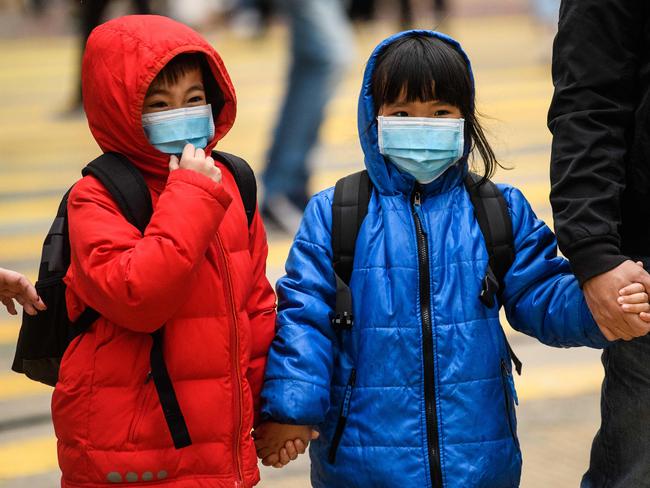 Children wearing face masks cross a road during a Lunar New Year of the Rat public holiday in Hong Kong following a coronavirus outbreak in the Chinese city of Wuhan. Picture: AFP