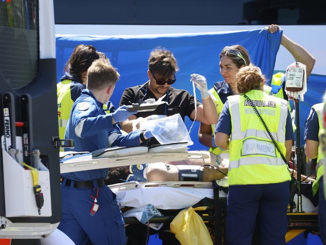 An injured person is transferred onto an ambulance. Picture: Jonathan Ng