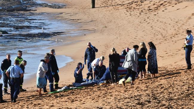 Bystanders and emergency services at Mona Vale Beach where a woman died this morning. Picture: Seb Dekker.