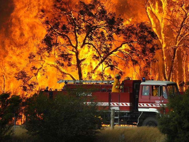 TAUS 60th Anniversary. A Country Fire Authority (CFA) fire truck is pictured in front of flames while fighting a bushfire at the Bunyip State Forest near the township of Tonimbuk, Saturday, Feb. 7, 2009. Authorities have issued urgent fire warnings to towns near a bushfire burning out of control east of Melbourne. (AAP Image/Andrew Brownbill)