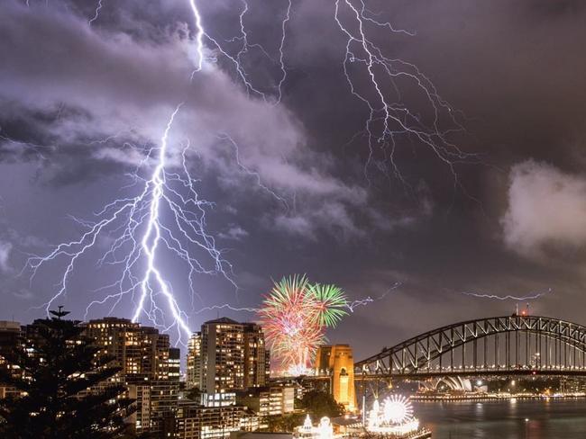 An incredible image of lightning crashing over Sydney Harbour as a fireworks display takes place nearby during a huge storm. Picture: @glanzpunkt