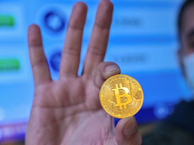 This photograph taken on December 17, 2020 shows a man holding a physical imitation of a Bitcoin at a crypto currency "Bitcoin Change" shop, near the Grand Bazaar, in Istanbul. - Leading virtual currency bitcoin on Wednesday traded above $20,000 for the first time following a sustained run higher in recent weeks. Bitcoin reached a record-high $20,398.50 before pulling back to $20,145, which was still an intra-day gain of nearly four percent. (Photo by Ozan KOSE / AFP)