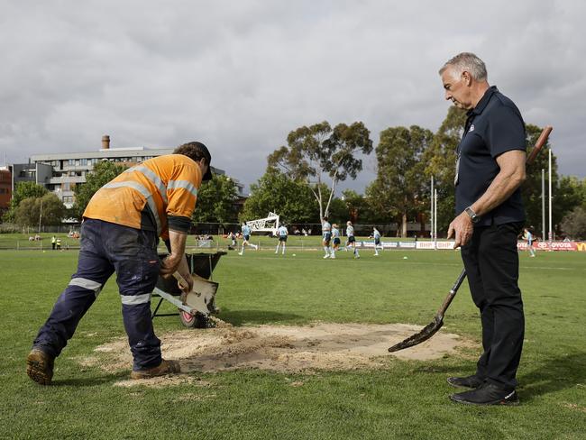 Sand is used to cover a hole in the ground due to a leak in an underground water pipe during the Pies and Crows’ clash on Sunday. Picture: Dylan Burns/AFL Photos via Getty Images.