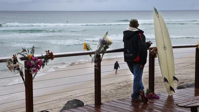 Surfers back in the line up at Greenmount Beach while lifeguards keep a wary eye on the water after the fatal shark attack on Nick Slater.