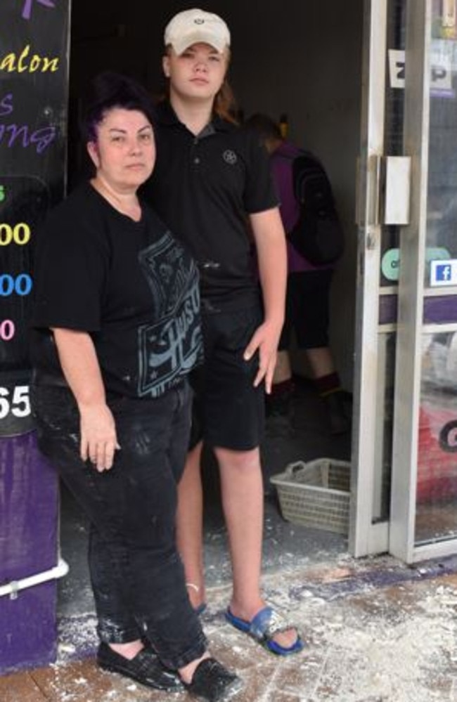 Roma Hair Salon owner Selina Stokes, and her son Justus Stokes spent Tuesday morning sweeping out the crumbling ceiling of the Mary St business after the floods inundated the entire building.