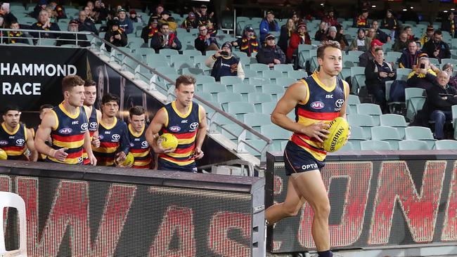 The Crows run out on to the oval, watched by fans in distanced seats. Picture: Sarah Reed