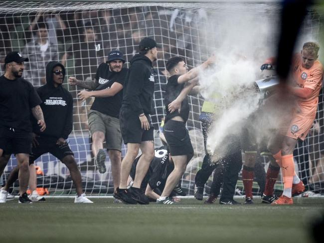 17/12/2022 Fans attack  Tom Glover of Melbourne City  after fans stormed the pitch during the round eight A-League Men's match between Melbourne City and Melbourne Victory at AAMI Park,