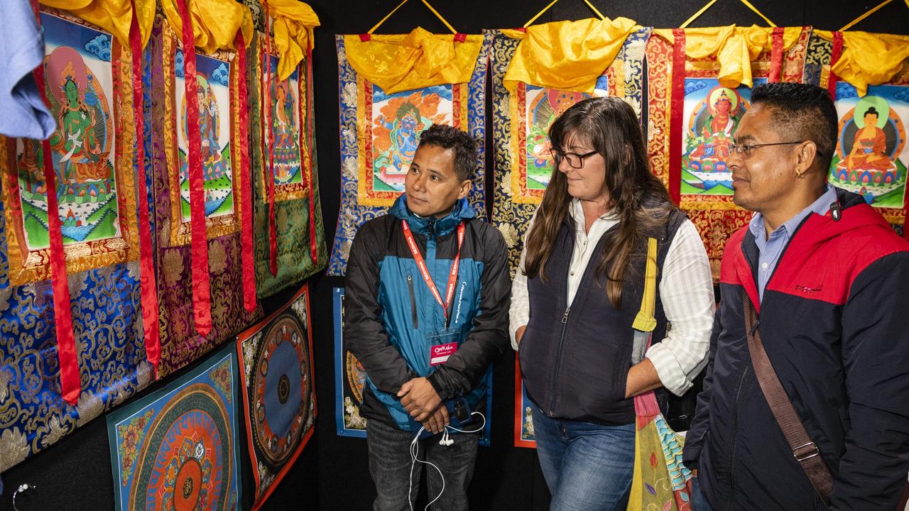 Abhaya Moktan (left) and Netra Chhatkuli of NS Handicraft Export show Debra Lynch the Nepalese thangkas on display at Craft Alive at the Goods Shed, Sunday, May 22, 2022. Picture: Kevin Farmer