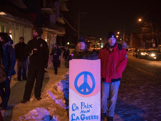 People stand with a peace sign near the mosque where two gunmen opened fire. Picture: AFP/Alice Chiche
