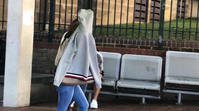 A camera-shy Stefane Ann Devine leaves Campbelltown Local Court.