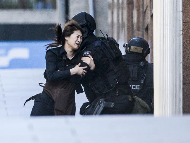 One of the most iconic images from the horrific Lindt Cafe siege — a hostage escapes. Picture: Chris McKeen