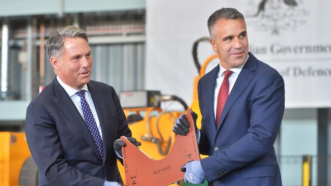 Defence Minister Richard Marles and South Australian Premier Peter Malinauskas hold the first cut piece of steel to be used on the first Hunter-class frigate to be constructed at the Osborne Naval Shipyard in Adelaide. Picture: NewsWire / Brenton Edwards