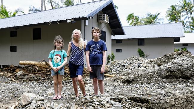 Katrina Weekes stands in the Ellis Beach holiday park with her daughter Riley, 7, and son Athan, 11, where huge landslides caused by flooding rain tore through the park on Sunday. Picture: Brendan Radke