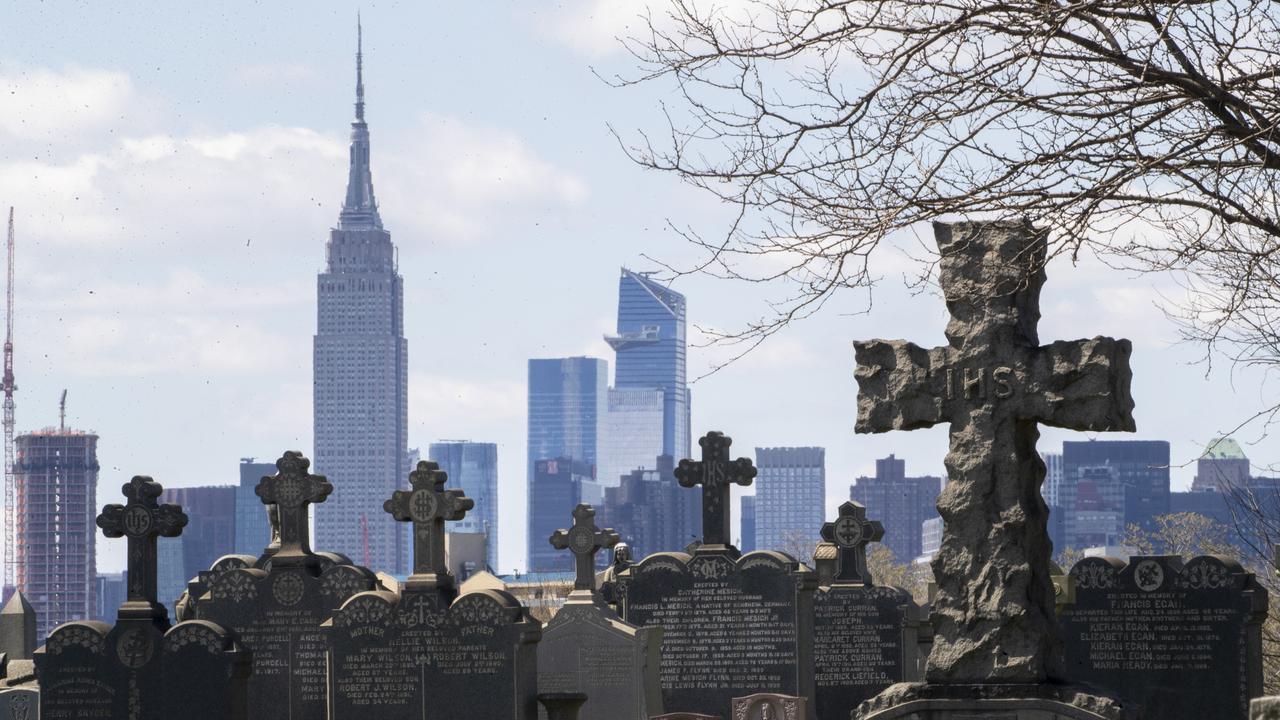 The Empire State building and the Manhattan skyline behind the tombstones at Calvary Cemetery in the Maspeth neighbourhood of Queens in New York on Saturday, April 11, 2020. Picture: AP /Mary Altaffer.