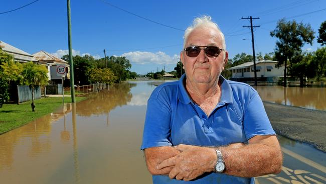 Depot Hill resident Eric Dare stands in front of a flooded street. Picture: Tim Marsden