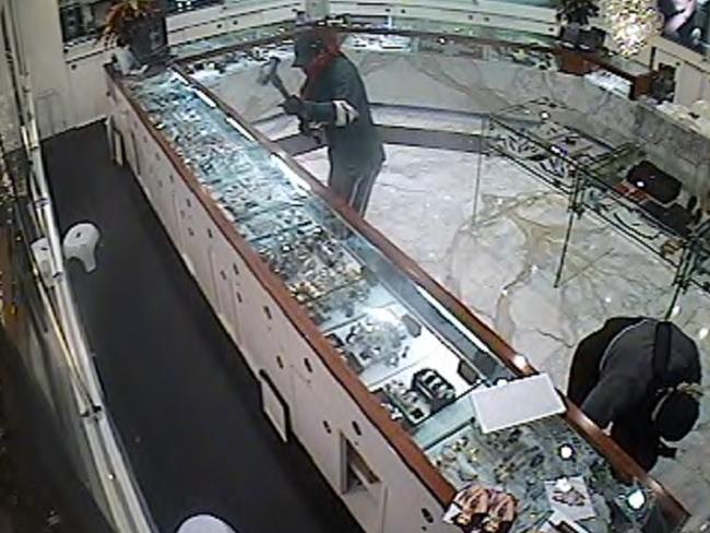 Still from security tape footage of three masked and armed men smashing display cabinets in Nader Jewellers in Westfield Shopping Centre at Parramatta.