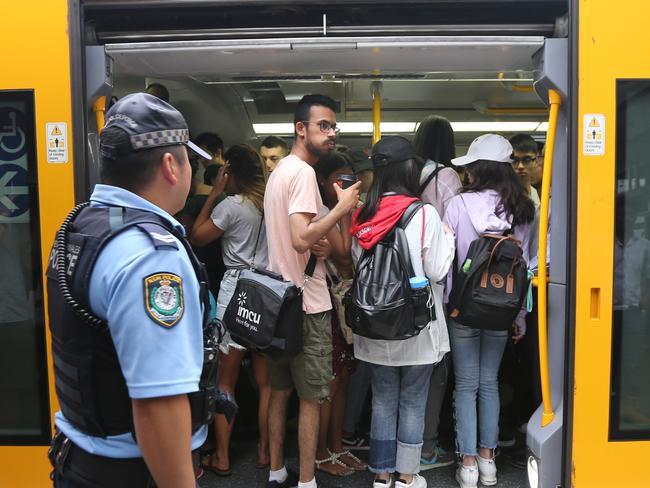 A police officer oversees commuters at Parramatta station during the reduced services period last Thursday. Picture: John Grainger