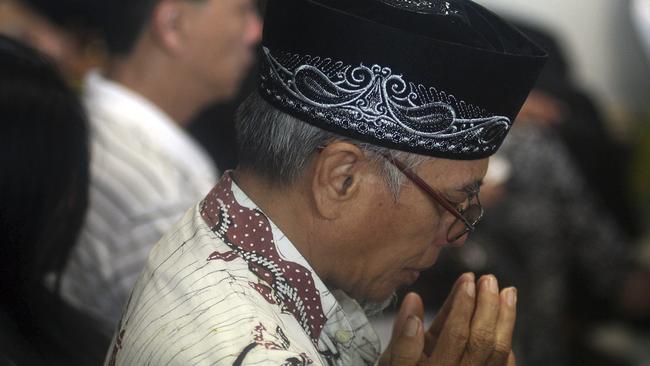 Relatives and next-of-kin of passengers on the AirAsia flight QZ8501 wait prayerfully for the latest news on the search of the missing jetliner at Juanda International Airport in Surabaya, East Java, Indonesia. Pic: AP Photo/Trisnadi Marjan.