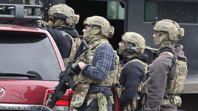 Heavily armed police outside the home during the siege. Picture: David Crosling