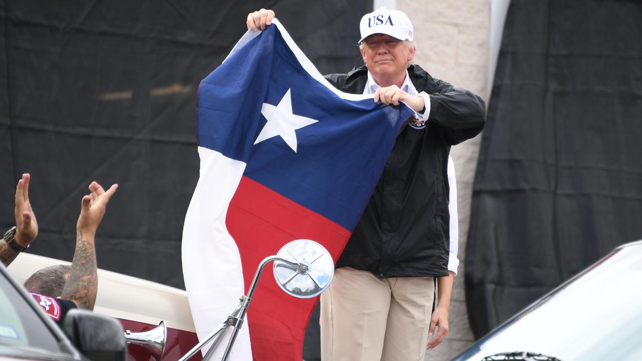 Donald Trump holding a Texas flag in 2017. Picture: AFP PHOTO / JIM WATSON.