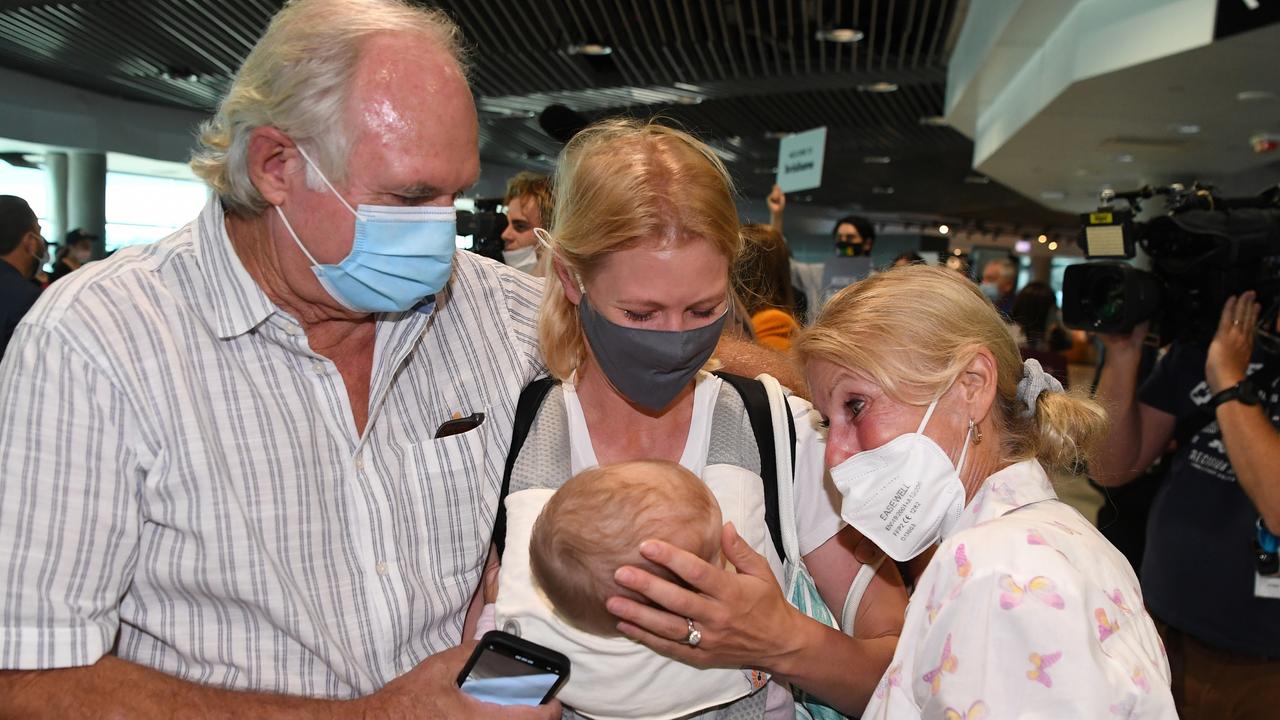 Alexandra Harg and her seven-month-old daughter Hazel are welcomed by her parents Maja and Rob Fyfe after she arrived on the first flight from Sydney into Brisbane's domestic terminal since border restrictions eased overnight. (Photo by Dan Peled/Getty Images)