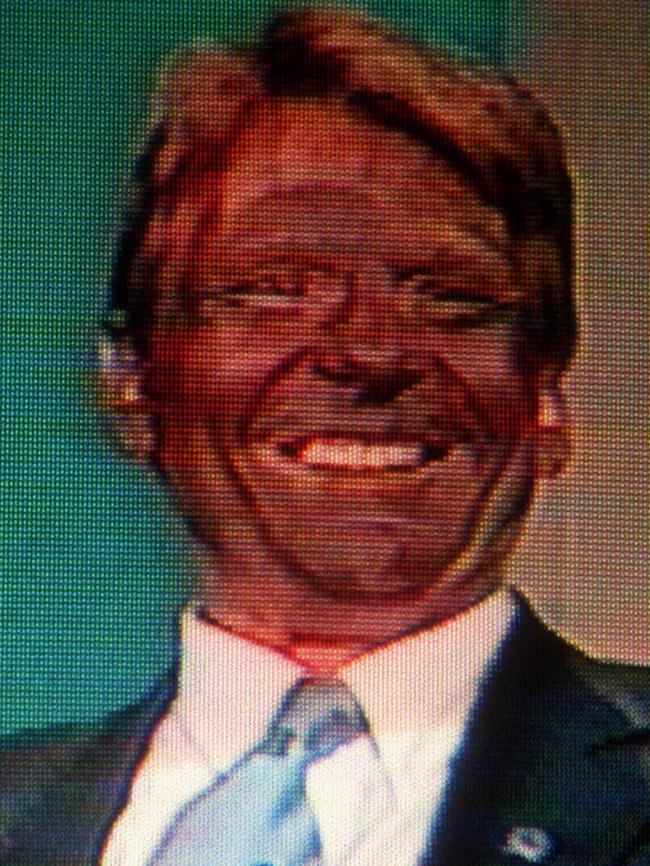 Sam Newman grins with his face painted black.