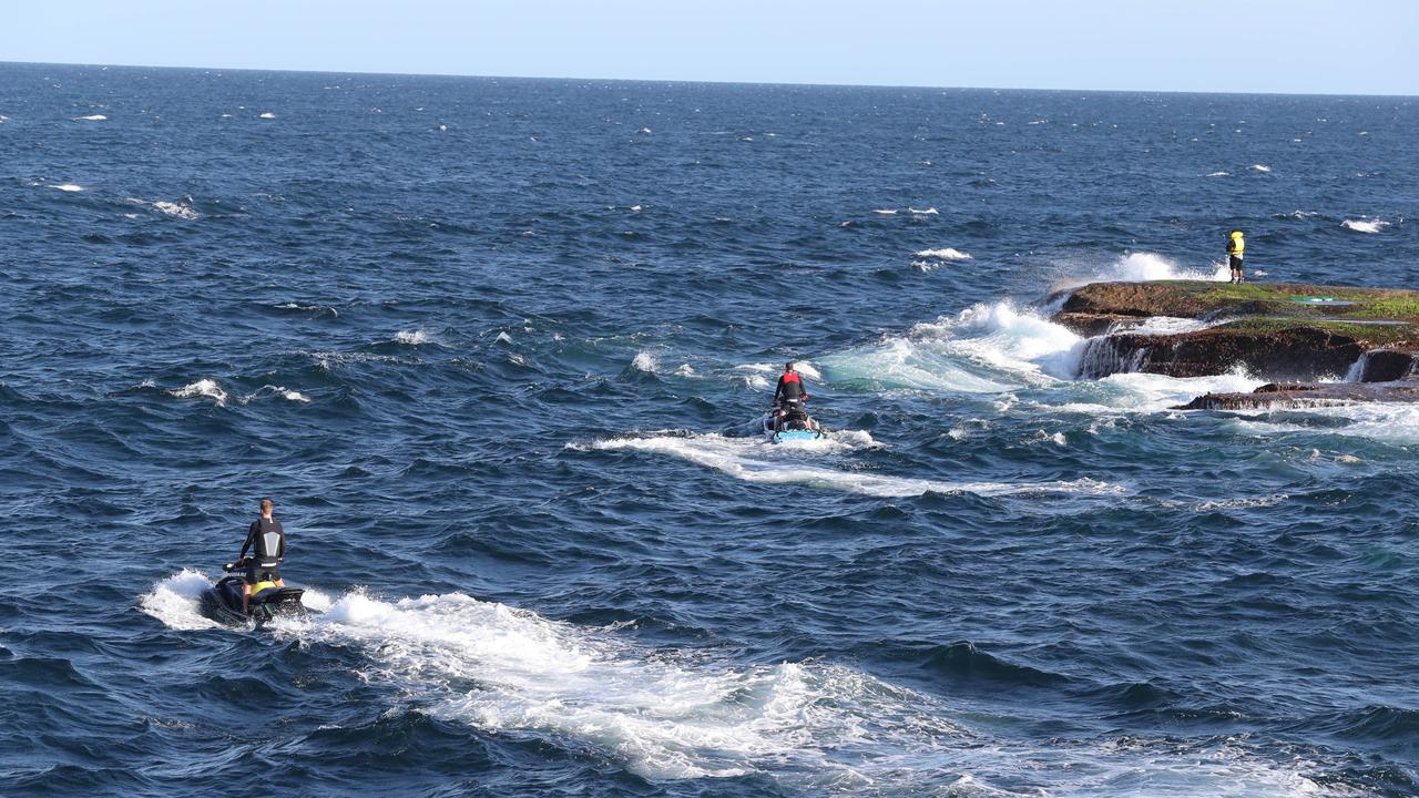 Police and surf rescue crews search the water following the attack. Picture: Richard Dobson