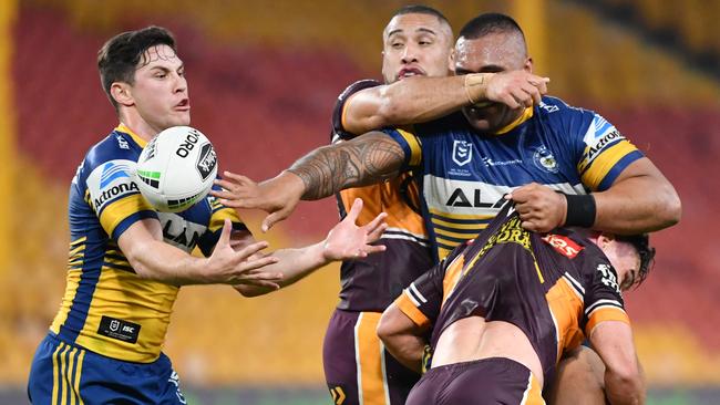 Parramatta prop Junior Paulo fires out a blind pass as halfback Mitchell Moses comes in to assist. Picture: AAP Image/Darren England