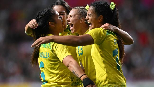 Australia's players celebrate their win at the end of the women's gold medal Rugby Sevens match between Australia and Fiji.