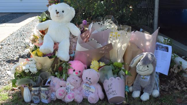 Flowers and teddy bears laid on the front yard of the Bean Street home. Picture: Aden Stokes