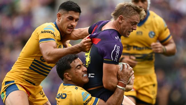 MELBOURNE, AUSTRALIA - MARCH 09:  Tyran Wishart of the Storm is tackled by Will Penisini and Dylan Brown of the Eels during the round one NRL match between the Melbourne Storm and the Parramatta Eels at AAMI Park on March 09, 2025, in Melbourne, Australia. (Photo by Quinn Rooney/Getty Images)