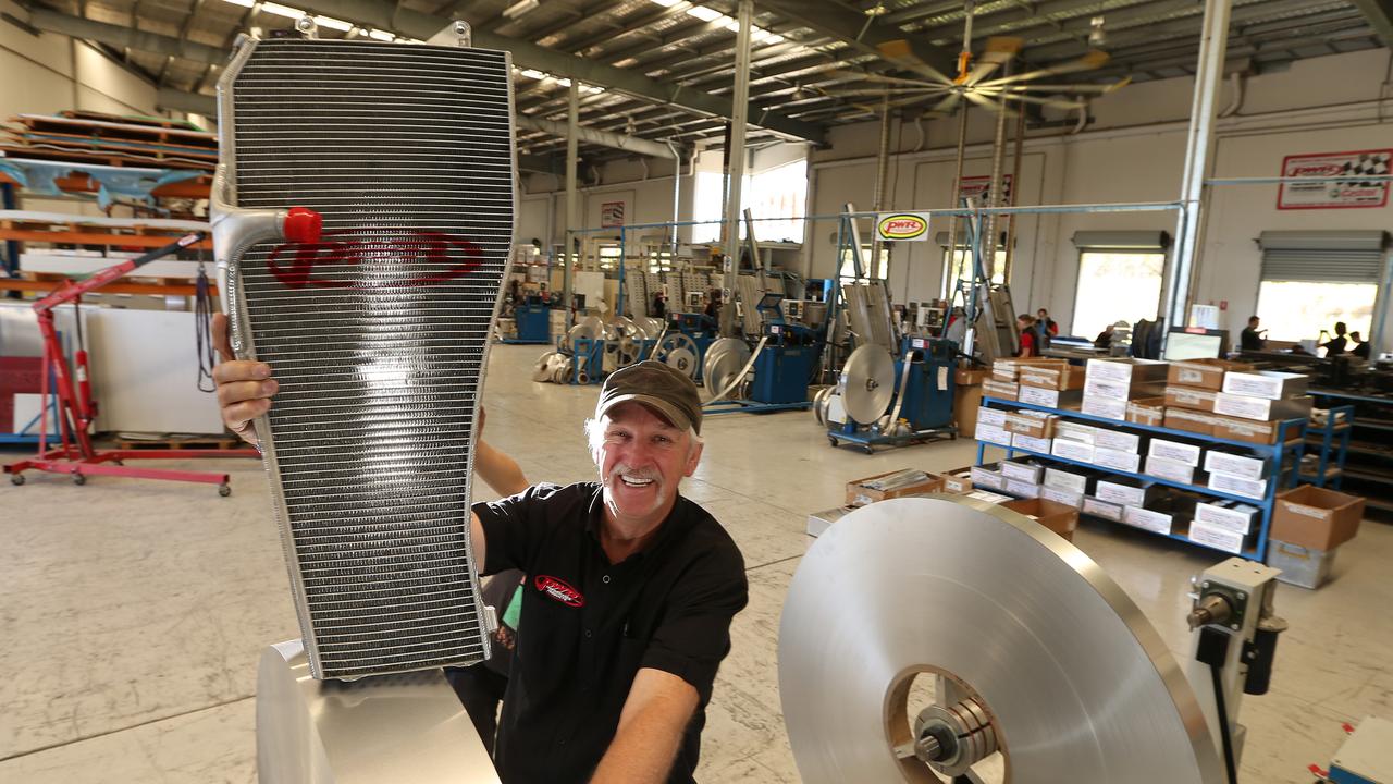 Kees Weel holds a $25000 radiator for a Formula One team in his factory.