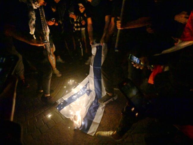 A crowd outside Sydney Opera House burns an Israeli flag. Picture: Jeremy Piper