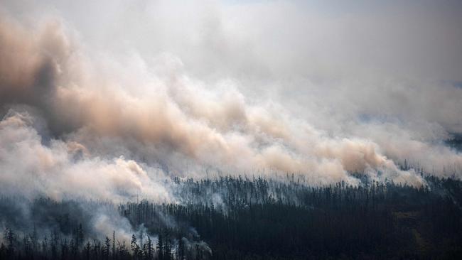 Smoke rises from a forest fire outside the village of Berdigestyakh, in the republic of Sakha, Siberia. Wildfires in western Siberia this year released record amounts of greenhouse gases, contributing to global warming. Picture: AFP