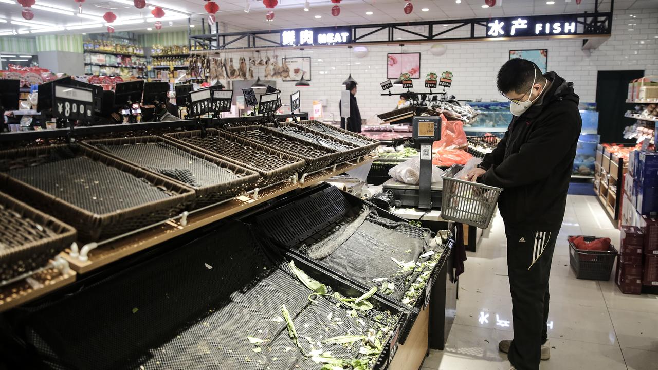 A resident wears a mask to buy vegetables in the market in Wuhan. Picture: Getty Images