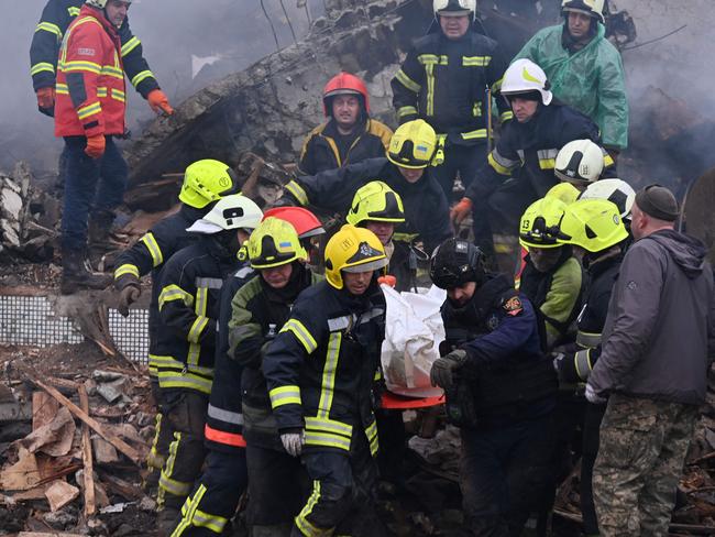 EDITORS NOTE: Graphic content / Firefighters carry the body of a civilian following a missile strike in Poltava on February 1, 2025, amid the Russian invasion on Ukraine. Russia fired 46 missiles and 123 drones including decoys at Ukraine overnight in a barrage that damaged buildings and left several people dead, the Ukrainian air force said on February 1, 2025. (Photo by SERGEY BOBOK / AFP)