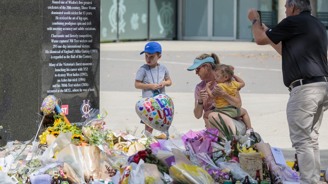 People continue to place flowers and other items at the Shane Warne statue at the MCG. Picture: NCA NewsWire / David Geraghty