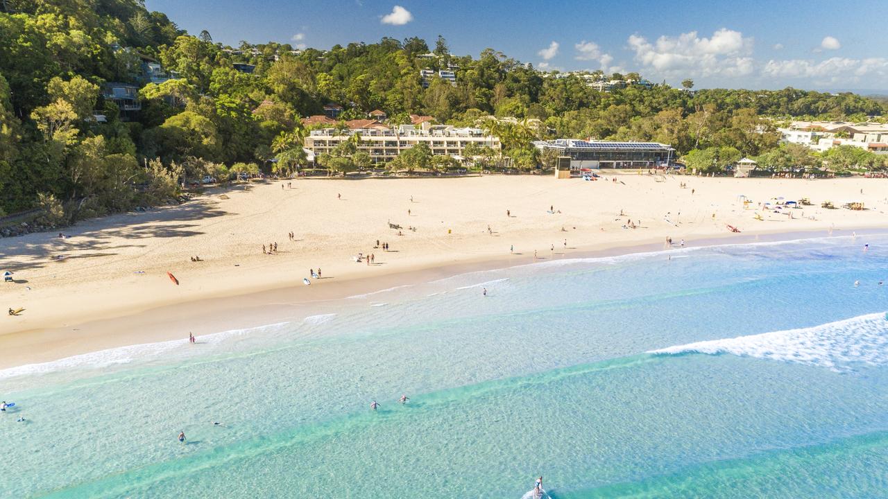 Surfers along Noosa Main Beach.