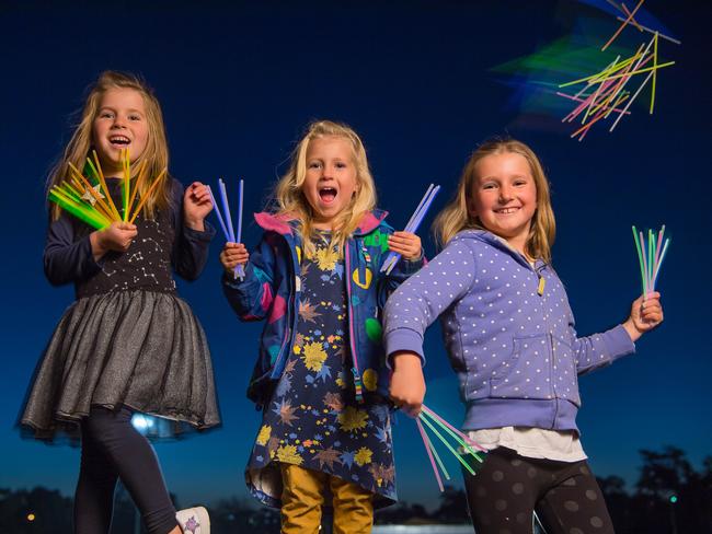 Sisters Vaiva, 5, Kira, 3 and Nina, 7 have fun with their glow sticks. Picture: Jason Edwards