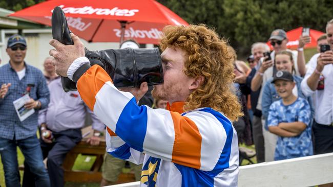 Thomas Doyle downing a bundy rum ‘shoey’ from his riding boots. . Picture: Rob Burnett Photography.